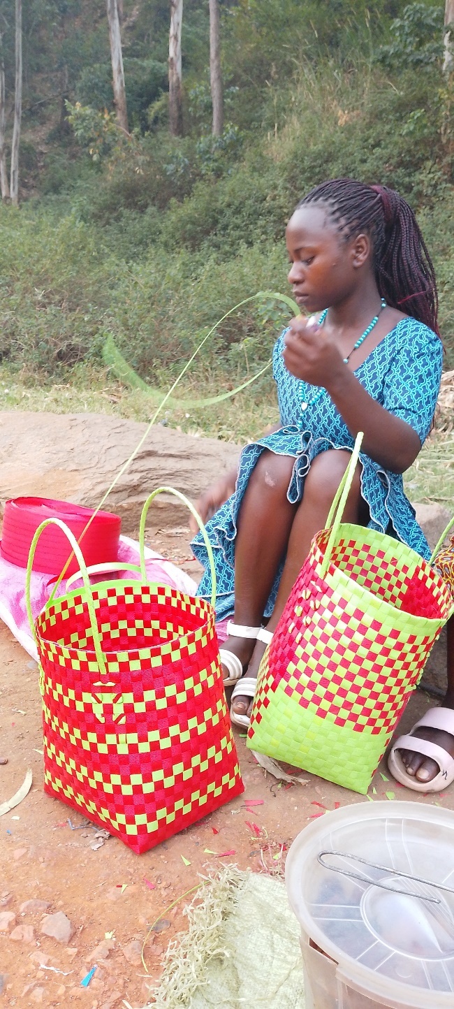 Biira shows baskets and pancakes from her small income-generating business.