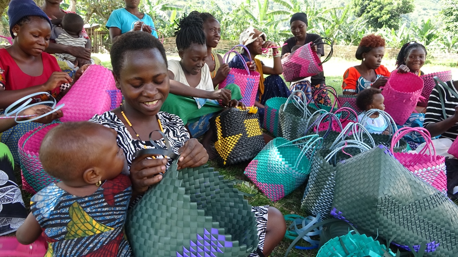 Biira during basket weaving sessions as her baby looks on.
