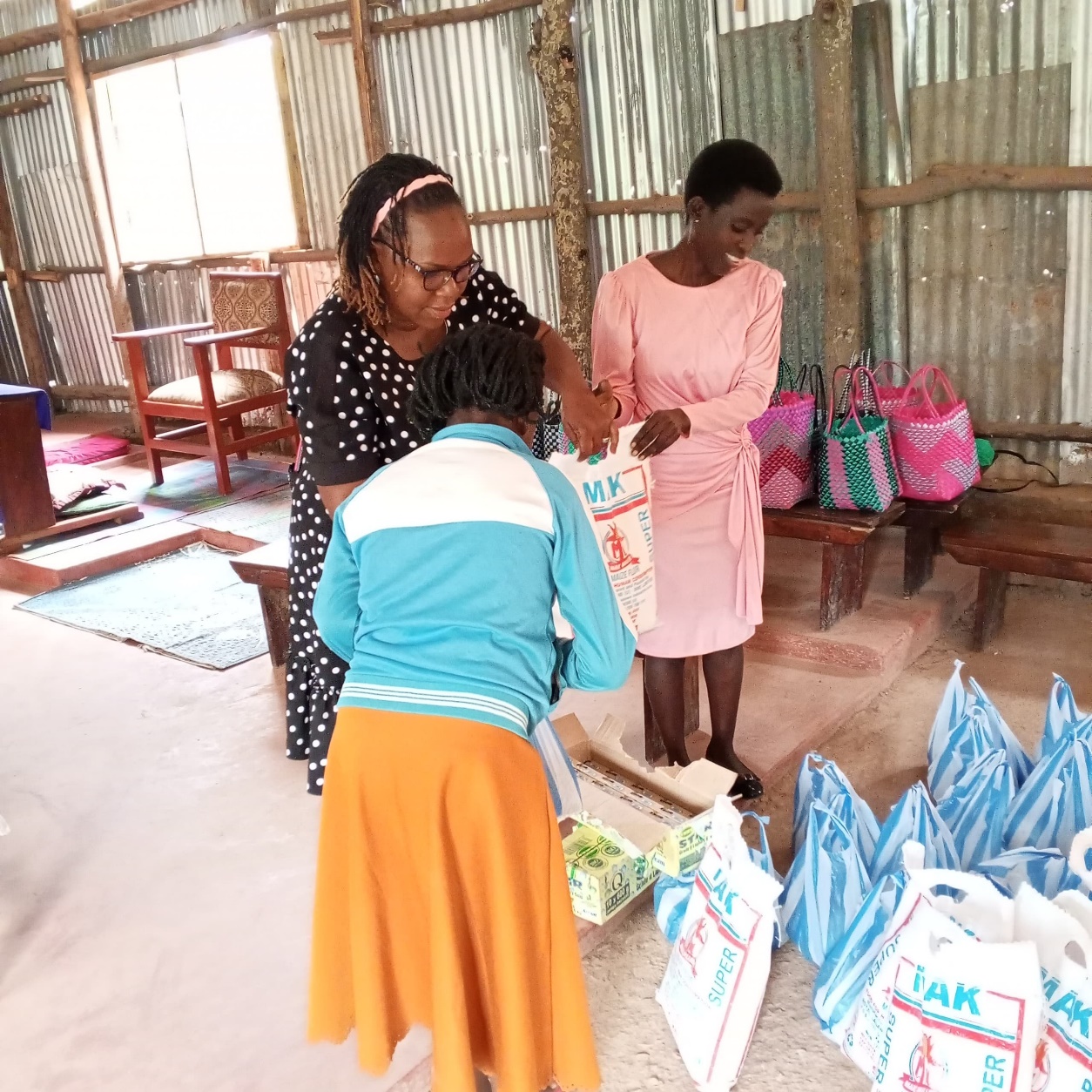 A teenage mother receives food support during a graduation ceremony.