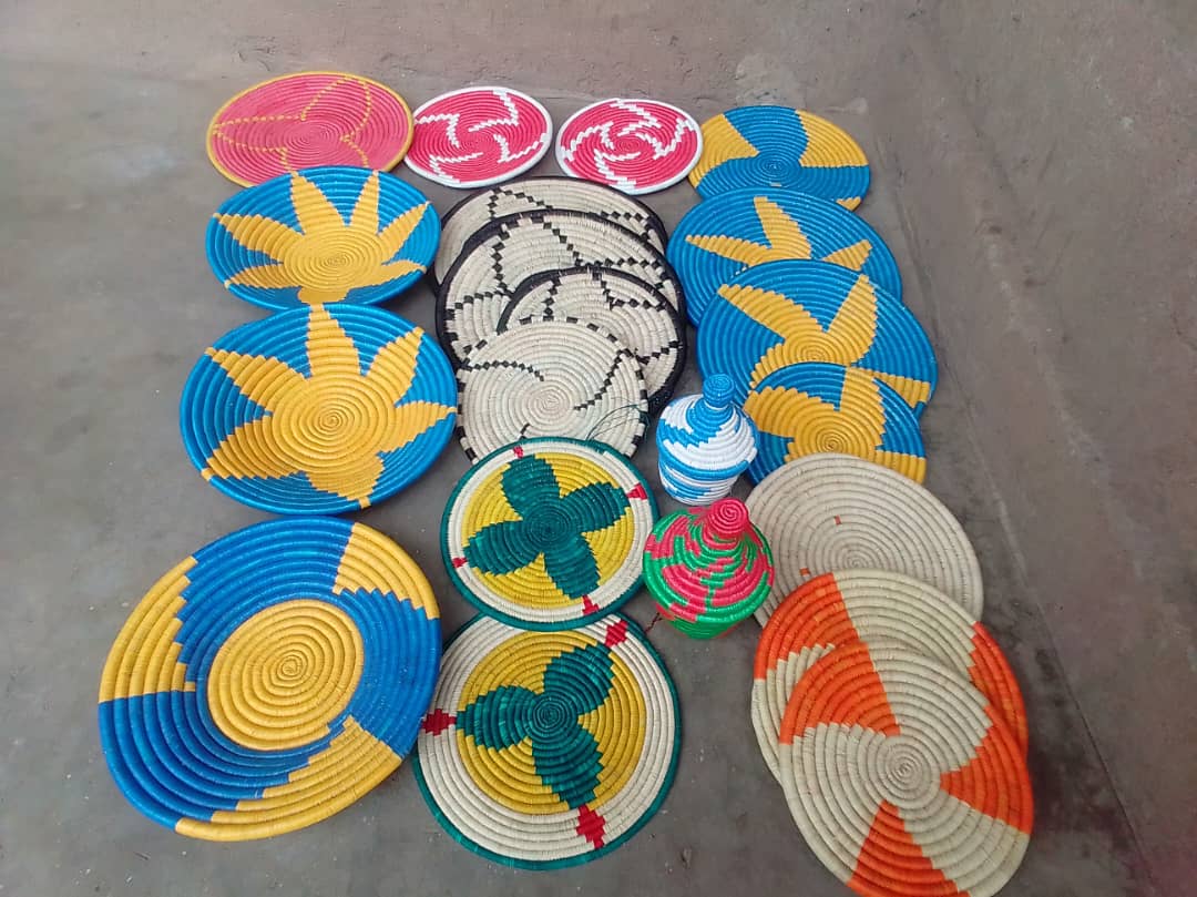 Assorted colorful handwoven mats displayed together.