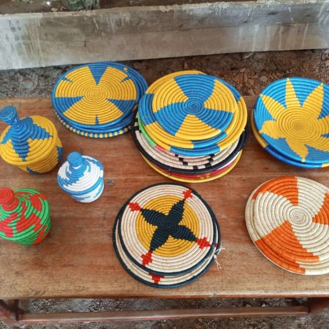 Handwoven decorative baskets and covered containers with colorful geometric patterns displayed on a wooden table.
