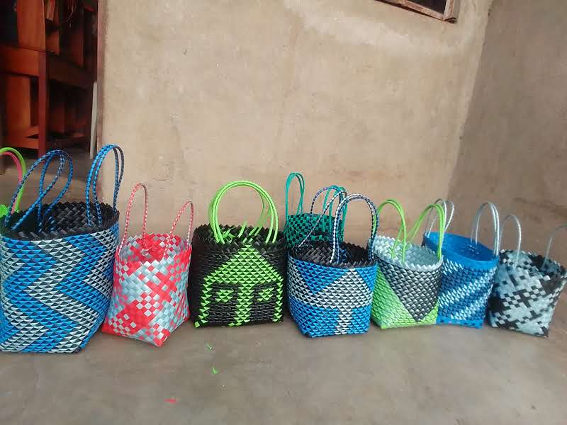 Colorful woven bags and baskets displayed together.